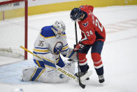 Washington Capitals' Connor McMichael (24) battles for the puck with Buffalo Sabres goaltender Linus Ullmark (35) during the first period of an NHL hockey game, Sunday, Jan. 24, 2021, in Washington. (AP Photo/Nick Wass)