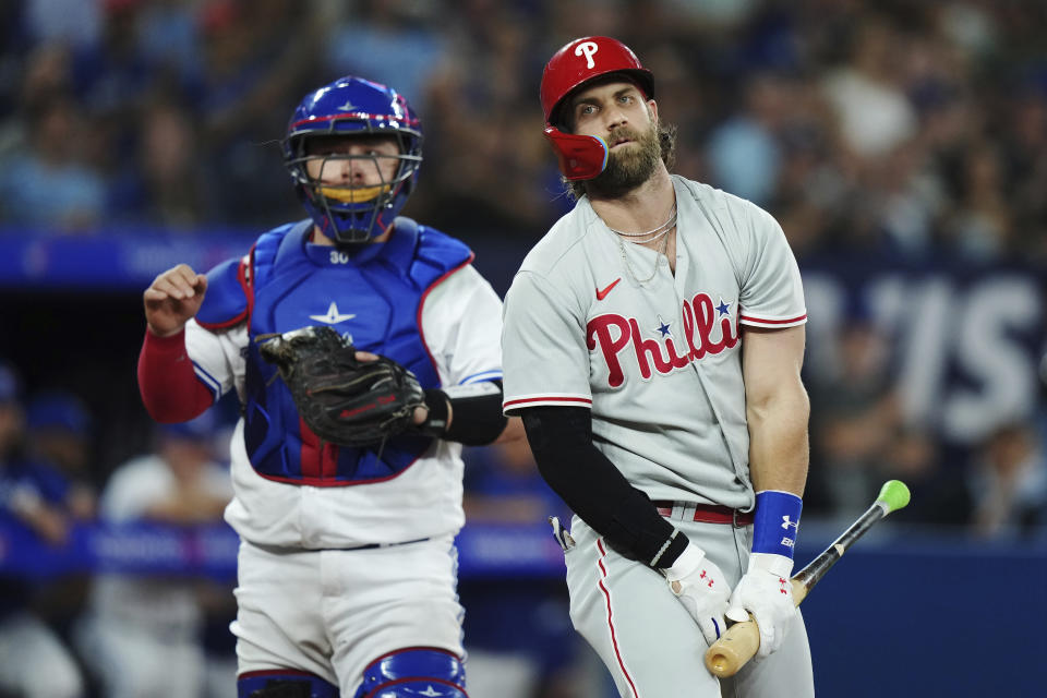 Philadelphia Phillies designated hitter Bryce Harper (3) reacts after striking out as Toronto Blue Jays catcher Alejandro Kirk (30) looks on during the ninth inning of a baseball game in Toronto on Tuesday, Aug. 15, 2023. (Nathan Denette/The Canadian Press via AP)