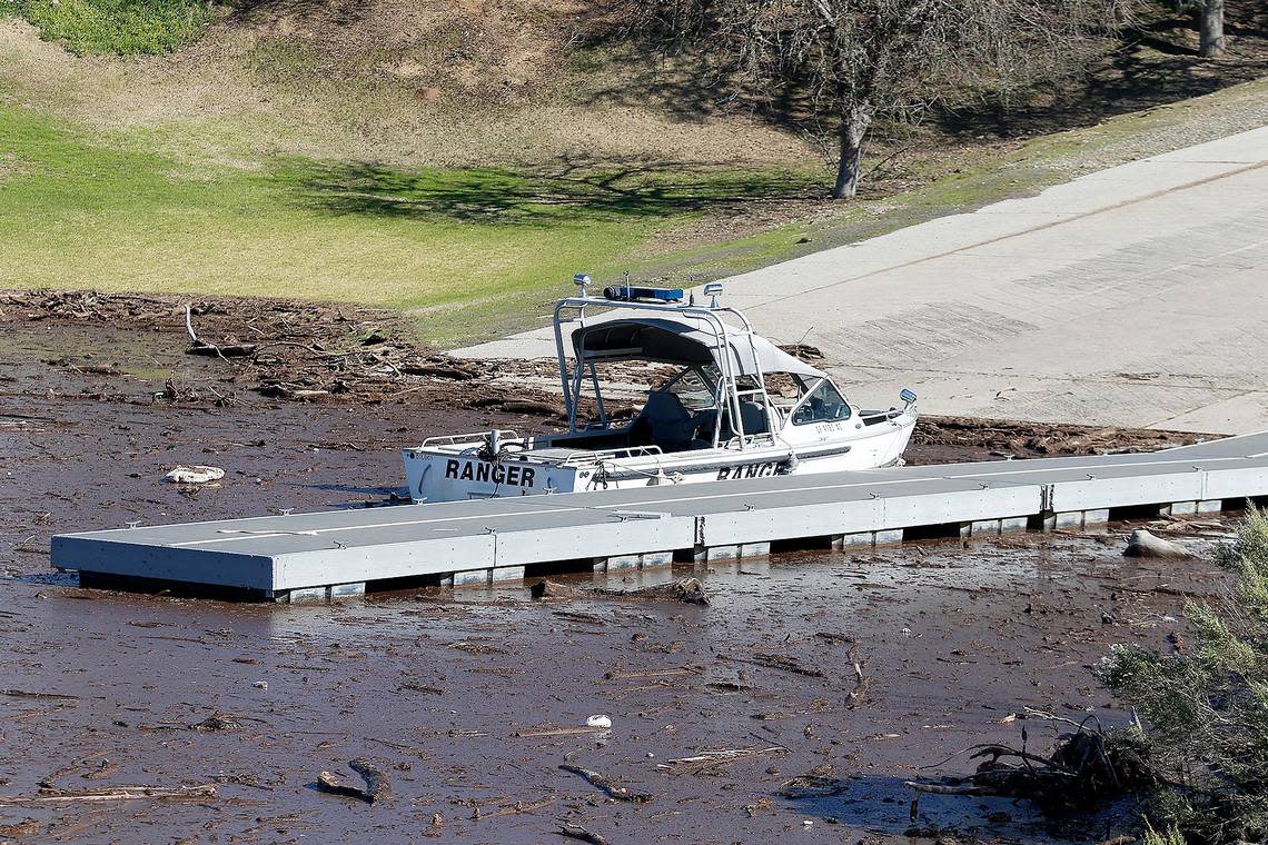 A Monterey County Park Ranger boat sits at a dock surrounded by debris that flowed into the lake during the big January storms.