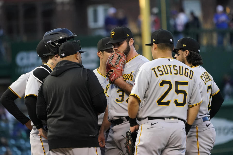 Pittsburgh Pirates starting pitcher Bryse Wilson, center, listens to pitching coach Oscar Marin during the first inning of the team's baseball game against the Chicago Cubs on Thursday, April 21, 2022, in Chicago. (AP Photo/Charles Rex Arbogast)