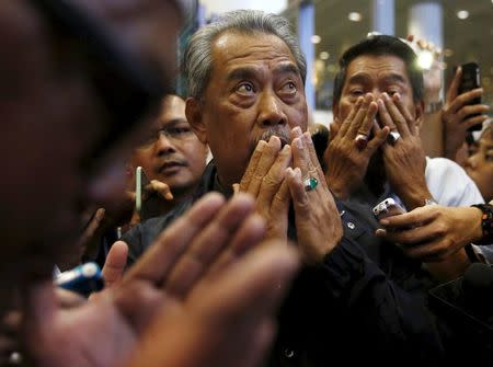 Malaysia's suspended Deputy Prime Minister Muhyiddin Yassin prays with supporters as he arrives at Kuala Lumpur International Airport in Sepang, Malaysia, March 1, 2016. REUTERS/Olivia Harris