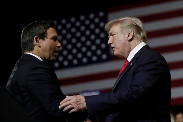 Donald Trump and Ron DeSantis talk to each other at a 2018 