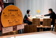 Una pareja cena en un restaurante de Zhengzhou, en la provincia de Henan, en el que un cartel indica las medidas de precaución que deben seguir los clientes. (Foto: Li An / Xinhua / Getty Images).