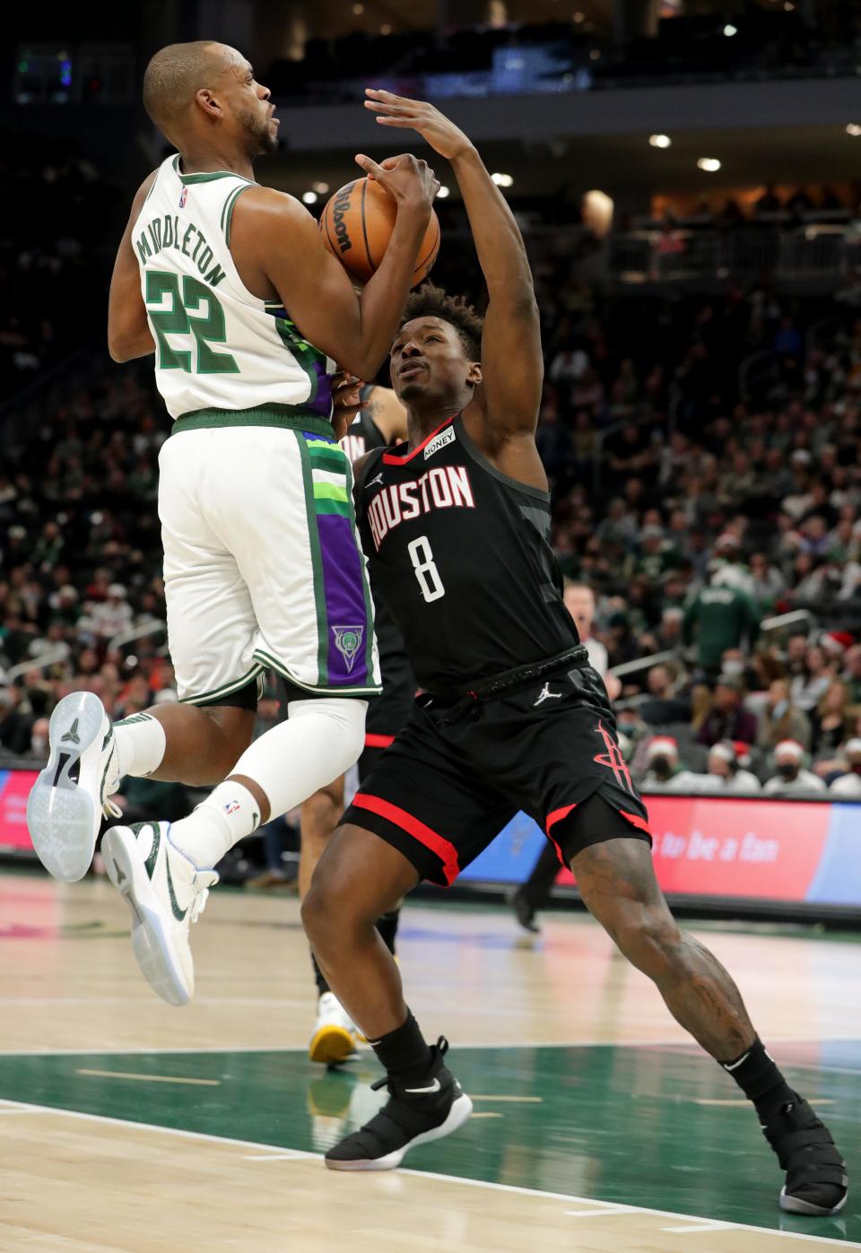 Milwaukee Bucks forward Khris Middleton (22) is fouled by Houston Rockets forward Jae'Sean Tate (8) during the first half of their game Wednesday, December 22, 2021 at Fiserv Forum in Milwaukee, Wis.MARK HOFFMAN/MILWAUKEE JOURNAL SENTINEL