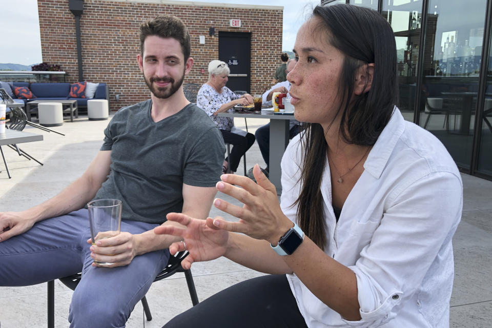 In this June 26, 2019 photo, Marco Teeter and Katherine Schaffer speaks at a rooftop bar at The Bristol Hotel in Bristol, Va. Ten medical students were on a tour of the city organized by a medical school with the aim of luring them to practice in rural communities facing health care shortages after graduation. (AP Photo/Sudhin Thanawala)