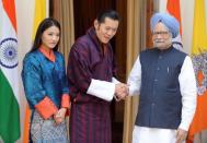 Bhutan's Queen Jetsun Pema watches as her husband King Jigme Khesar Namgyel Wangchuck, centre, shakes hands with Indian Prime Minister Manmohan Singh in New Delhi. The newly married king and queen are on their first official overseas trip together, visiting close ally India for high-level talks and some sight-seeing