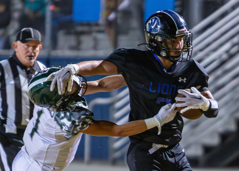 Cathedral City's Rene Romero stiff-arms a Twentynine Palms defender during their high school football game on Sept. 22, 2023.