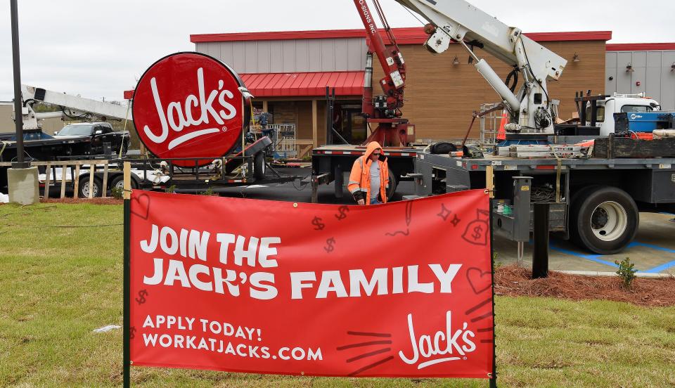 A work crew raises the sign for the new Jack's restaurant on University Blvd. in Alberta Friday, Feb. 25, 2022.