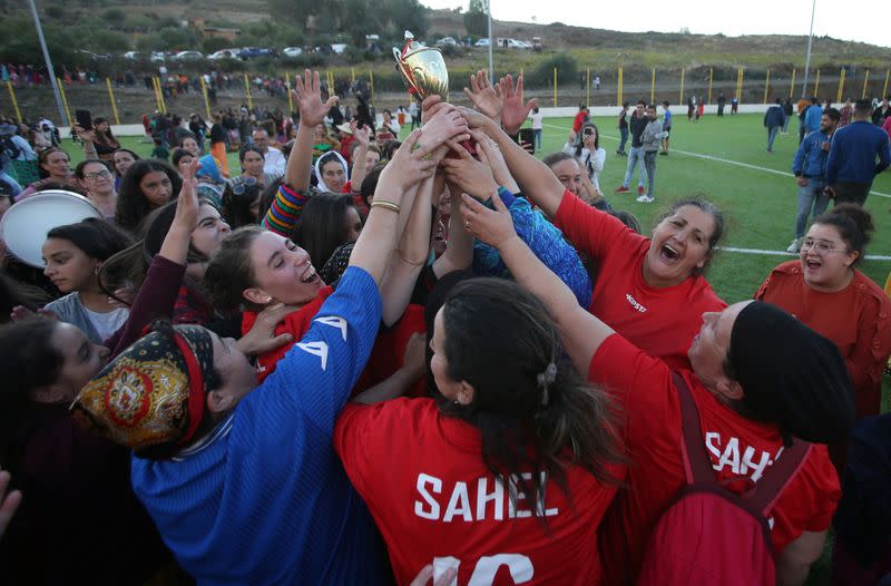 Women soccer team lift the trophy as they celebrate winning in an annual local soccer tournament, in the village of Sahel
