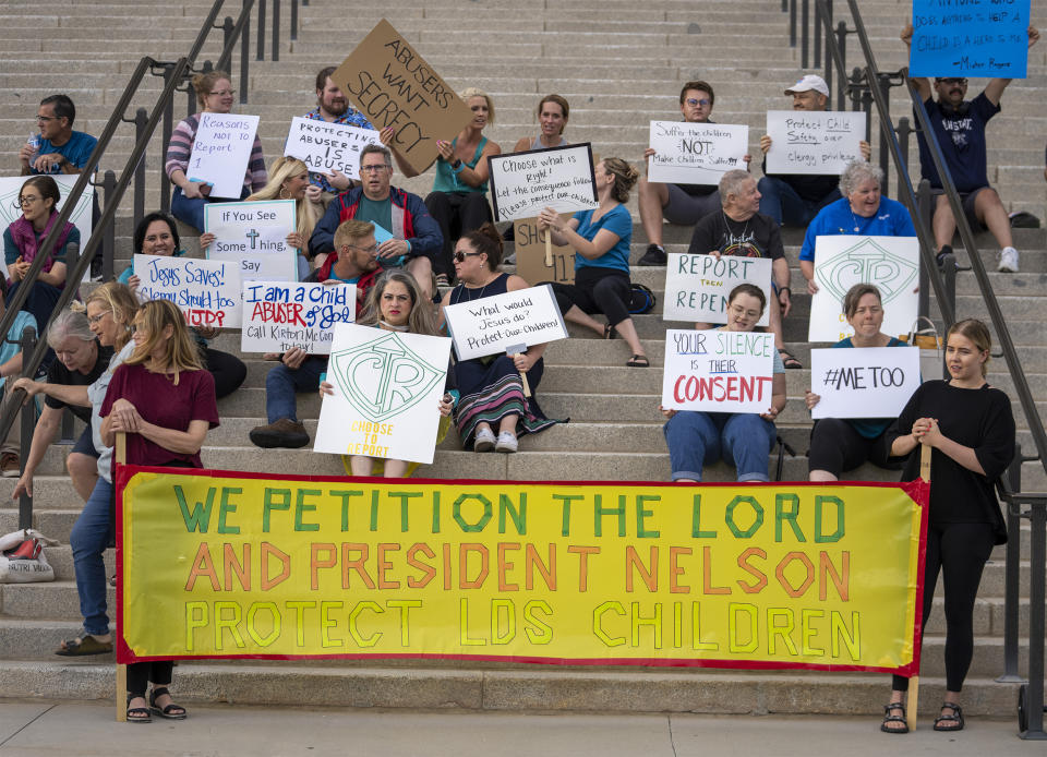 FILE - Protesters gather on the steps of the Utah State Capitol, at a rally to gain support for removing the clergy exemption from mandatory reporting in cases of abuse and neglect, on Friday, Aug. 19, 2022, in Salt Lake City. A push to mandate that members of religious clergy report child sexual abuse when it's brought to their attention is facing pushback from churches throughout the United States. That's the case in Utah, where four separate proposals to narrow the so-called clergy-penitent privilege loophole have not received hearings in the statehouse as lawmakers prepare to adjourn for the year. (Rick Egan/The Salt Lake Tribune via AP, File )