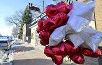 A bouquet of balloons and candles are displayed on the sidewalk left as a memorial in St. Paul, Minn., on Tuesday, Dec. 6, 2022, where a man was fatally shot by St. Paul Police Monday evening in the Dayton's Bluff neighborhood of St. Paul. (John Autey/Pioneer Press via AP)