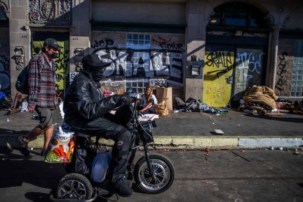 File photo: People walk by the Skid Row neighbourhood of downtown Los Angeles on 25 November (AFP via Getty Images)