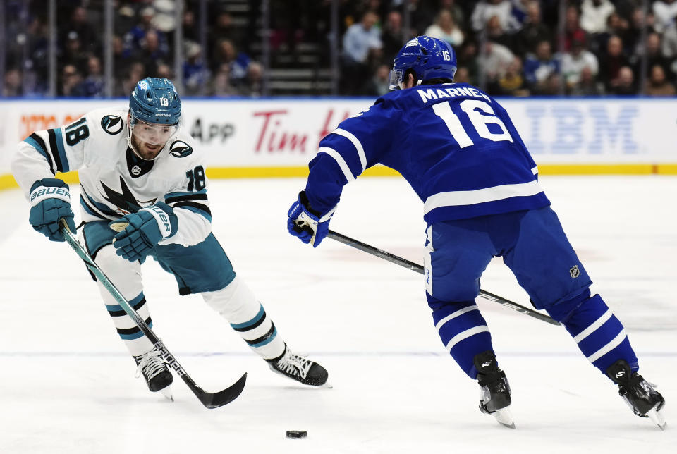 San Jose Sharks forward Filip Zadina (18) tries to get past Toronto Maple Leafs forward Mitchell Marner (16) during the first period of an NHL hockey game, Tuesday, Jan. 9, 2024 in Toronto. (Nathan Denette/The Canadian Press via AP)