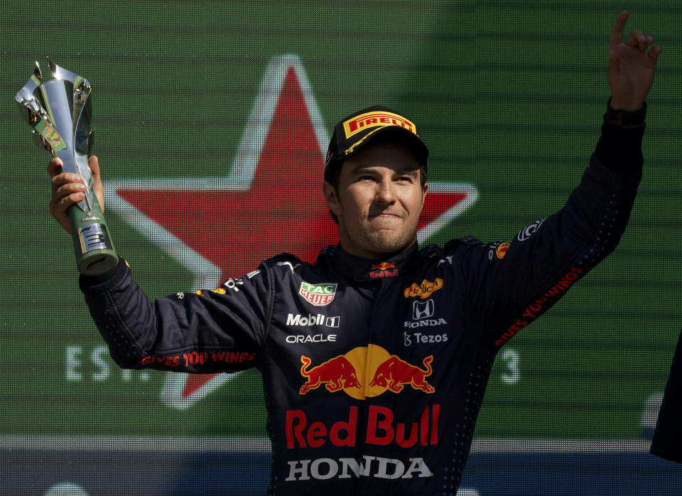 Red Bull's Sergio Perez celebrates winning third place of the Formula One Mexico Grand Prix auto race at the Hermanos Rodriguez racetrack in Mexico City, Sunday, Nov. 7, 2021. (AP Photo/Fernando Llano)