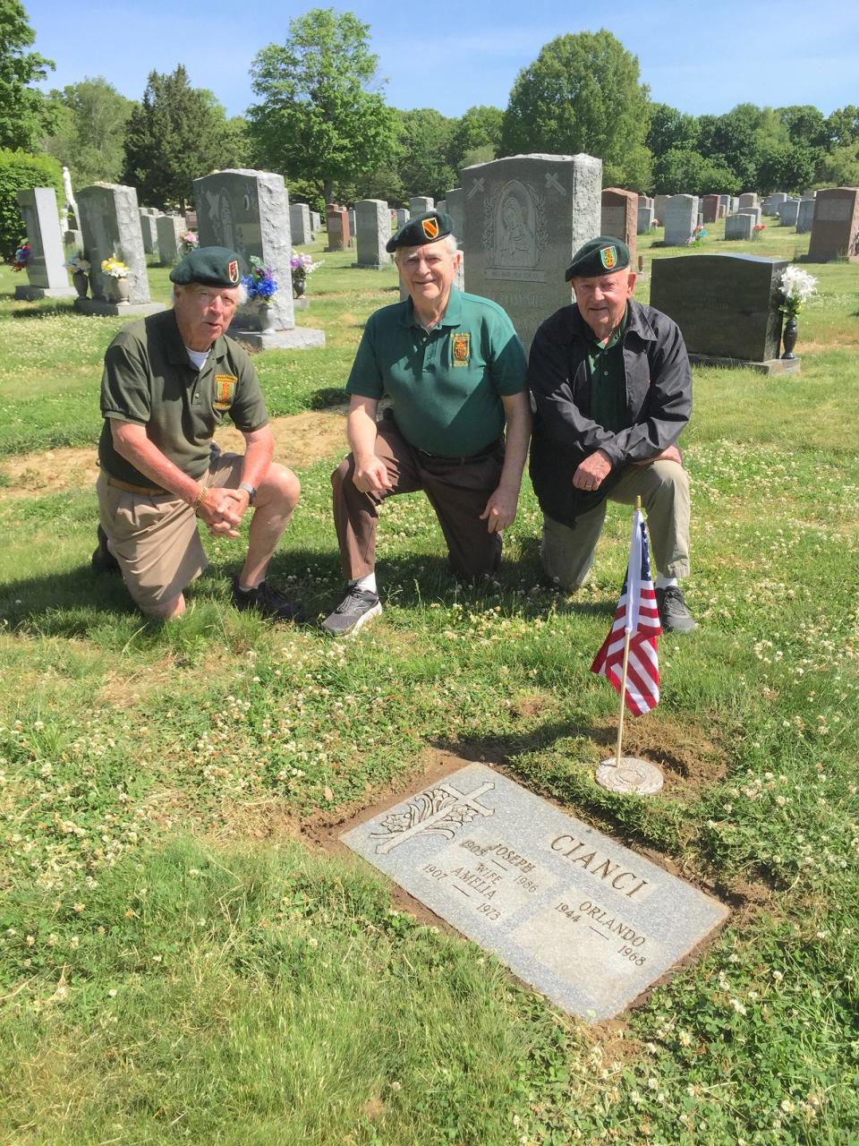 Special Forces veterans John Hardman, Frank Lennon and Steve Kelly kneel by the just-tended gravestone of fellow Special Forces soldier Orlando Cianci at St. Ann’s cemetery last week.