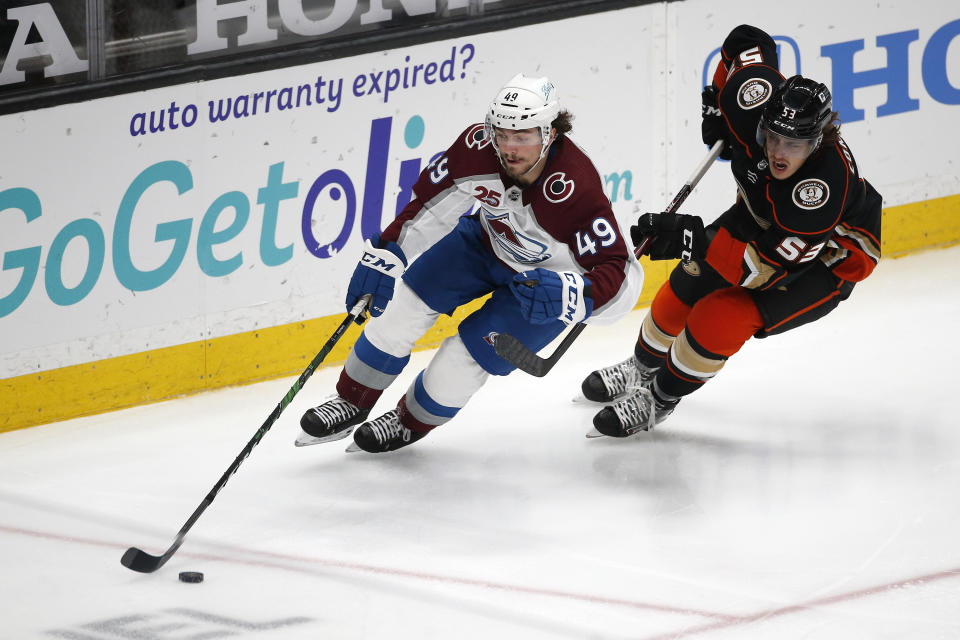 Colorado Avalanche defenseman Samuel Girard (49) works with the puck next to Anaheim Ducks forward Maxime Comtois (53) during the second period of an NHL hockey game in Anaheim, Calif., Friday, Jan. 22, 2021. (AP Photo/Ringo H.W. Chiu)