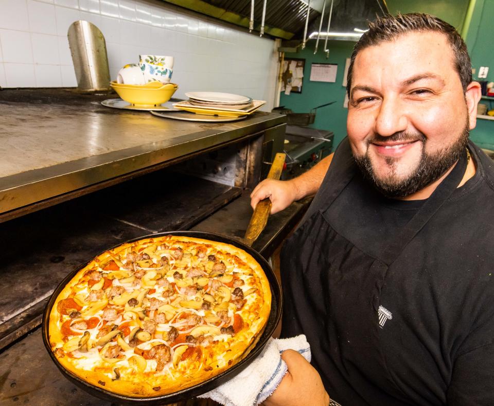 Nick Angelidakis pulls the Lakis House Favorite Pizza out of the oven after about 15 minutes on Feb. 7, 2023 at Lakis Greek Restaurant in Ocala. "We use a pan and it takes about 15 minutes to bake it" Angelidakis said. The restaurant has been open since 1984 and Angelidakis says that the secret to a perfect pizza is "love."