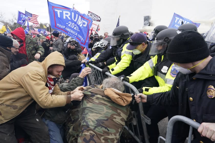 Protesters attempt to force their way through a police barricade in front of the Capital