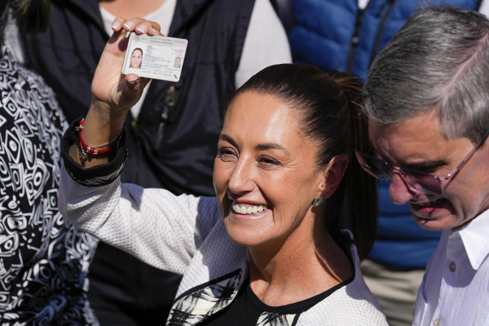 Ruling party presidential candidate Claudia Sheinbaum shows her ID as she leaves a polling station where she voted during general elections in Mexico City, Sunday, June 2, 2024. (AP Photo/Matias Delacroix)