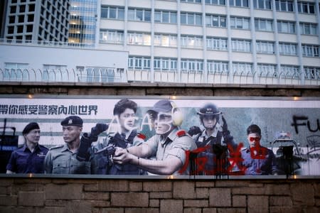 FILE PHOTO: Graffiti against the extradition bill is seen on a Hong Kong Police department banner outside of police headquarters in Hong Kong