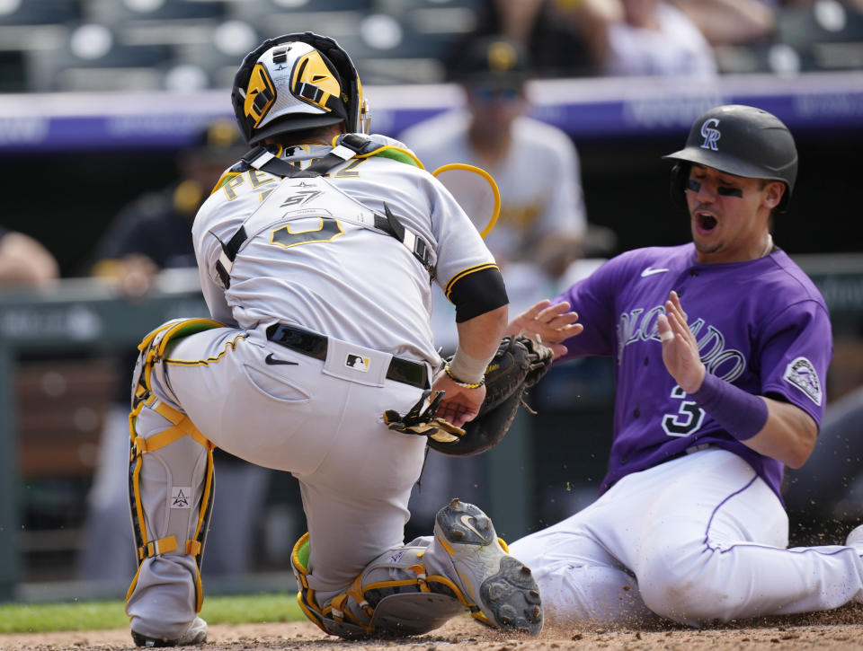 Pittsburgh Pirates catcher Michael Perez, left, tags out Colorado Rockies' Dom Nunez to end the seventh inning of a baseball game Wednesday, June 30, 2021, in Denver. (AP Photo/David Zalubowski)