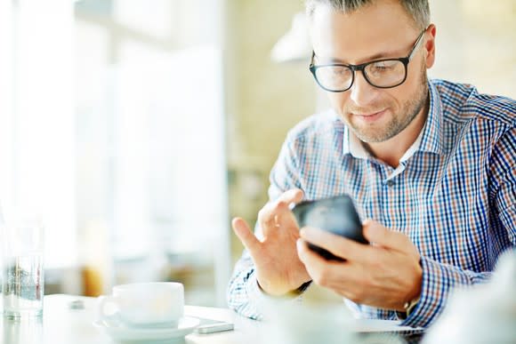 Businessman in dress shirt looking at content on mobile device.