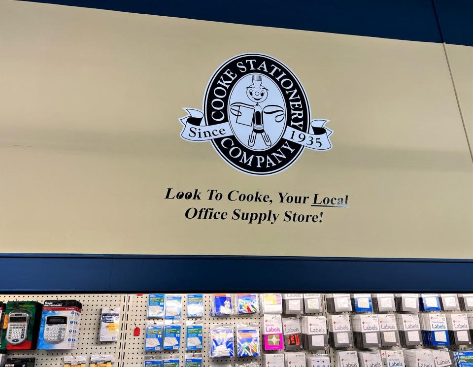 Cooke Stationery Company's longtime logo features a character made of office supplies, a typewriter eraser wheel with brush for the head and hair, rubber bands for the arms, and paper clips for the legs.