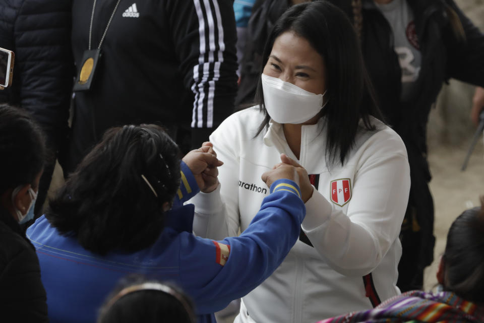 Presidential candidate Keiko Fujimori greets a woman upon her arrival to a breakfast with supporters in Lima, Peru, Sunday, June 6, 2021. Peruvians head to the polls Sunday in a presidential run-off election to choose between Fujimori, the daughter of jailed ex-President Alberto Fujimori, and political novice Pedro Castillo. (AP Photo/Guadalupe Pardo)