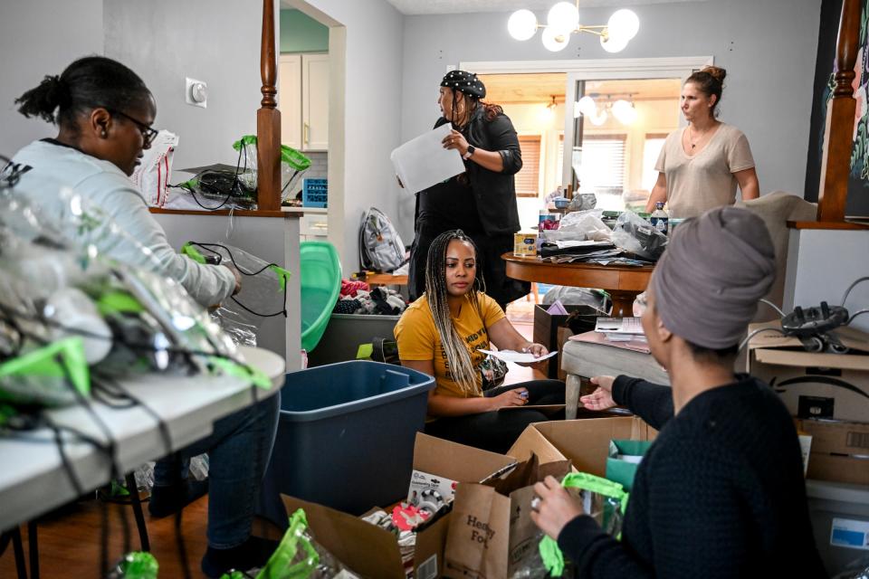 North Star Birthing Center owners Sharde' Burton, center, and Domonique Brace, center, top, along with volunteers Shajuana Tyson, left, and Amber Irrer, background right, and intern Amina Mohame, right, work to get all the supplies sorted and packed for their upcoming community baby shower on Wednesday, March 13, 2024, at Brace's home in Lansing.