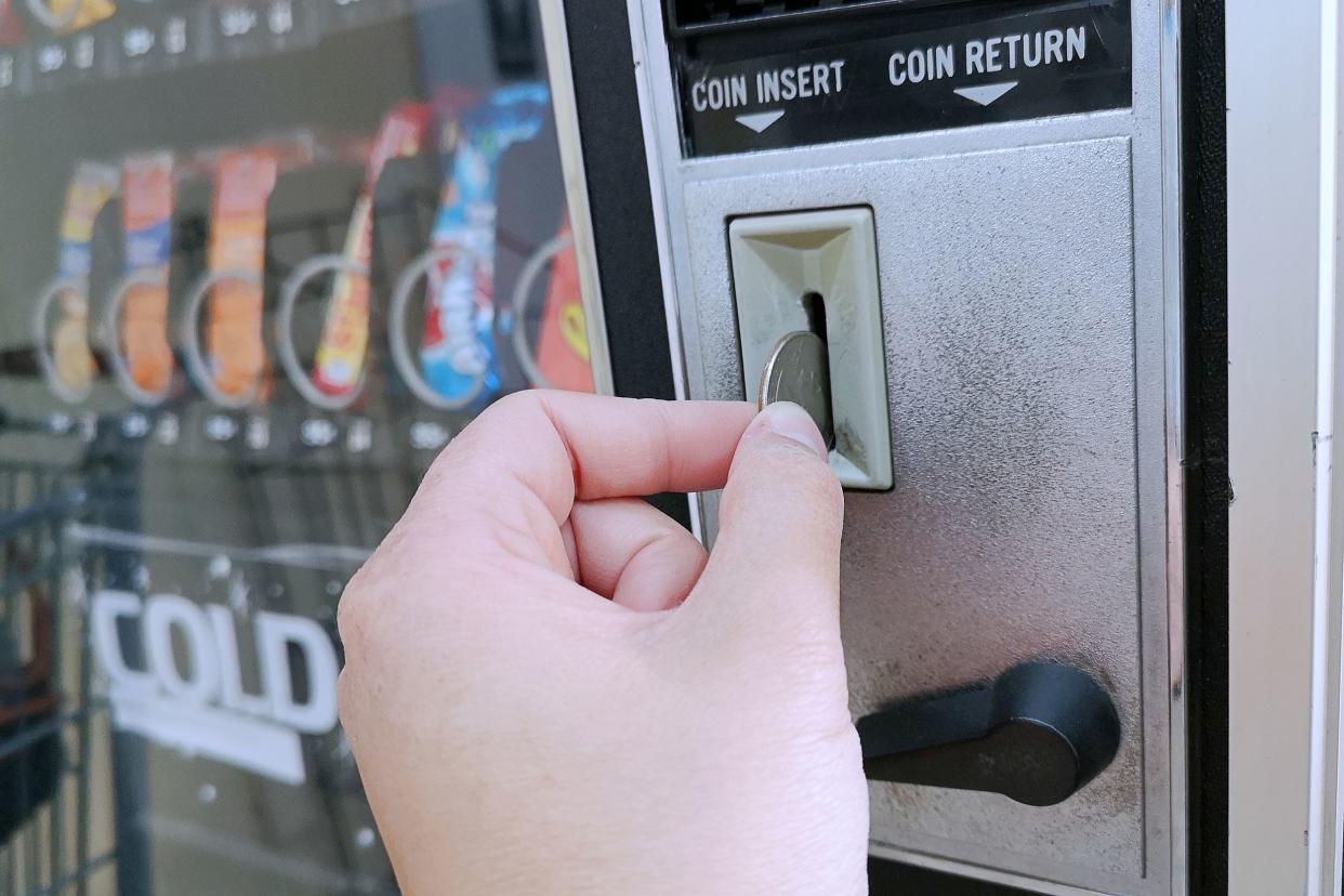 paying with a quarter coin in a vending machine