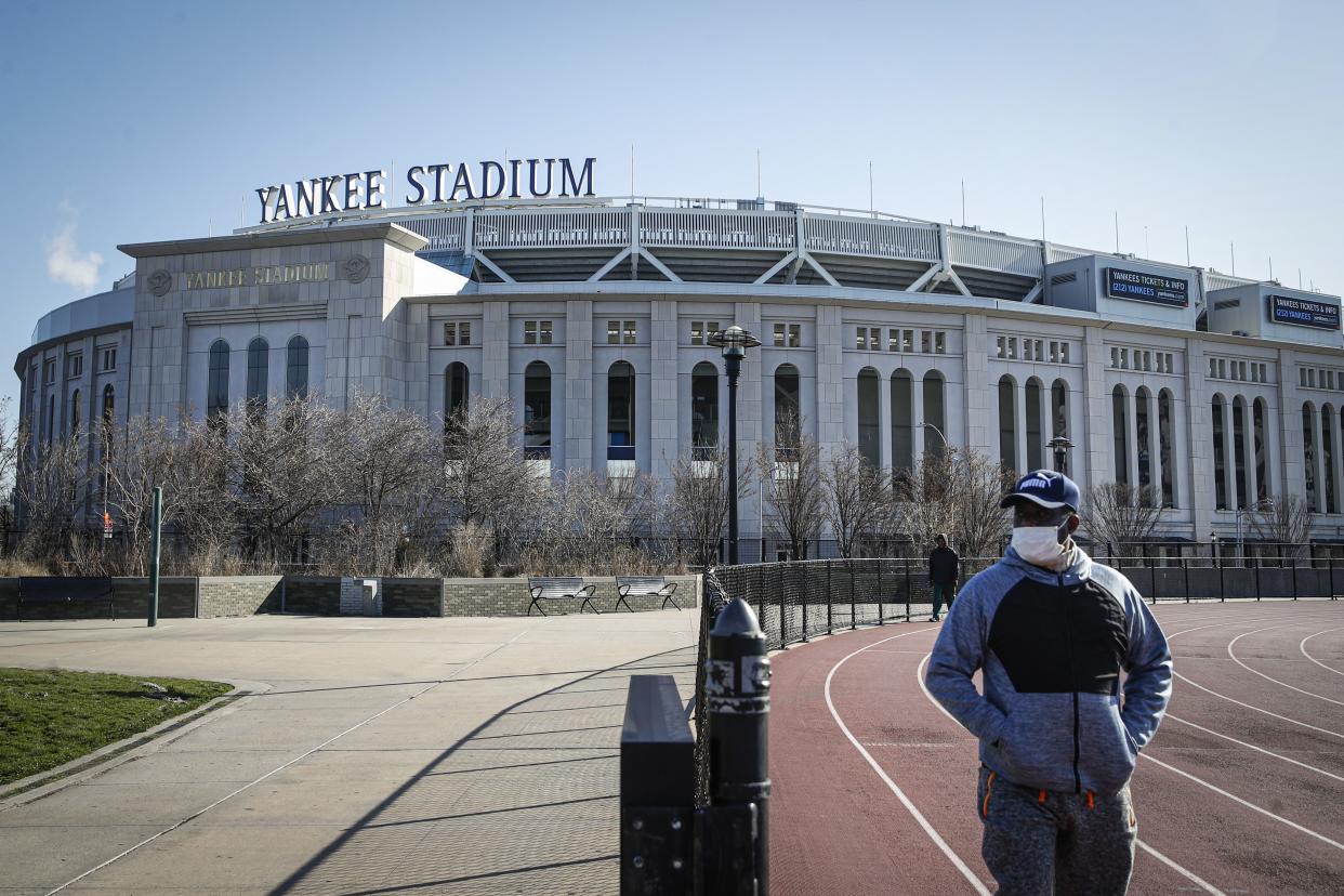 A pedestrian walks a running track while wearing a surgical mask near Yankee Stadium as it remains closed due to COVID-19 concerns in the Bronx borough of New York. 