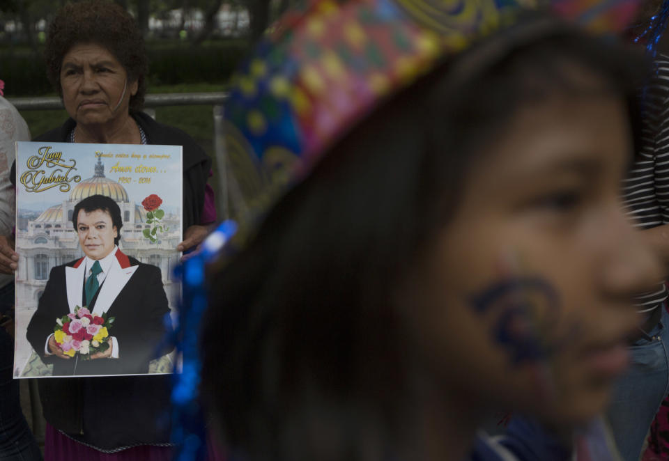 People gather outside the Palace of Fine Arts to pay tribute to Mexico's late Latin music legend Juan Gabriel.