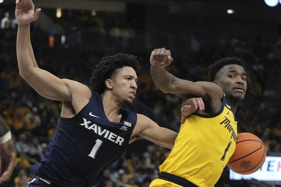 Marquette's Kam Jones tries together past Xavier's Desmond Claude during the first half of an NCAA college basketball game Sunday, Feb. 25, 2024, in Milwaukee. (AP Photo/Morry Gash)