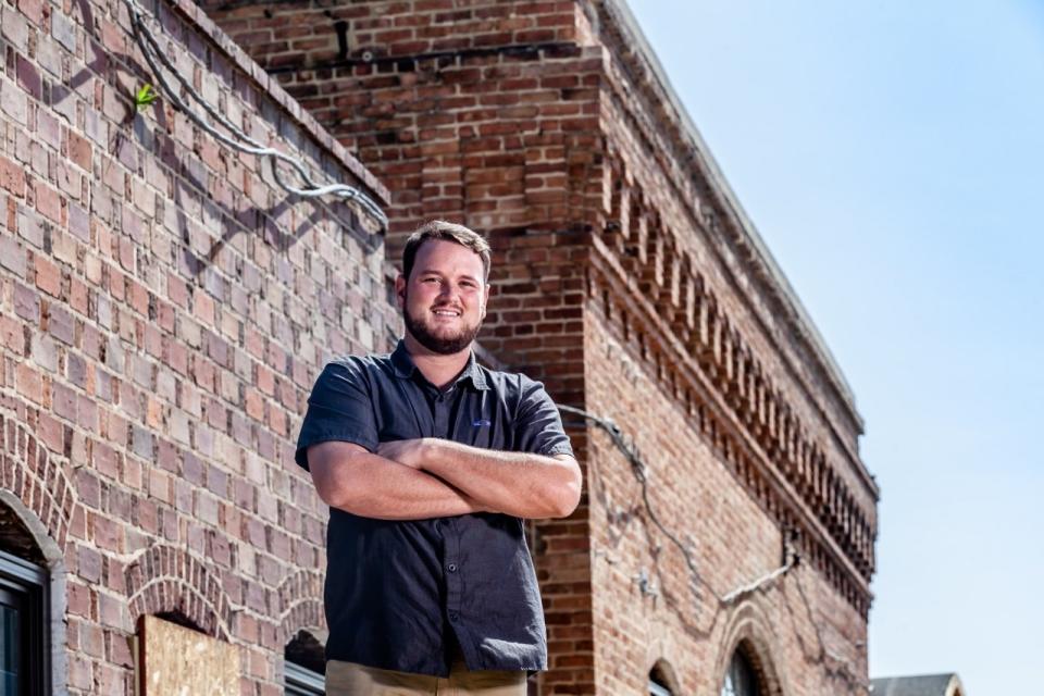 Mitchell stands outside a former steam plant renovated into the Pinehurst Brewing Company,.