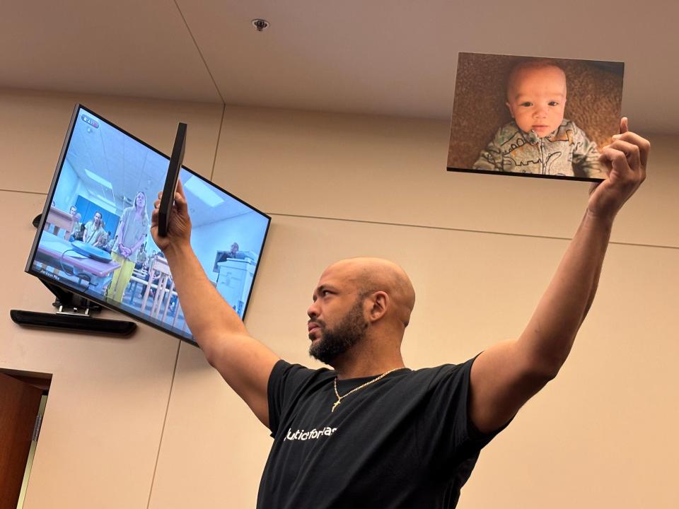 Jontue Chatman holds up photos of his infant son, Kashan Roman Crawford-Chatman, on Wednesday in Franklin County Common Pleas Court at the arraignment of Tammra Straughter, a Reynoldsburg home daycare operator whom the prosecutor's office has accused of shaking 5-month-old Kashan, causing his death in October 2023.