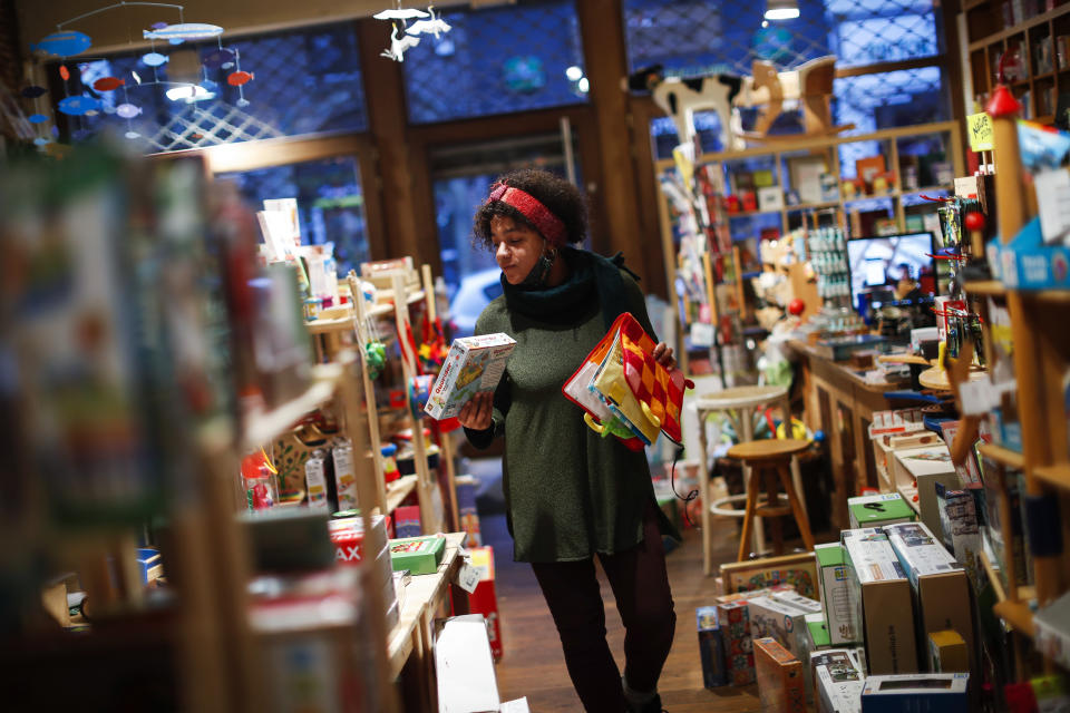 Sarah De Kinkajou, owner of Kinkajou toy shop, organises items before opening her business in Brussels, Tuesday, Dec. 1, 2020. Non-essential shops in Belgium are reopening on Tuesday in the wake of encouraging figures about declining infection rates and hospital admissions because of the coronavirus. (AP Photo/Francisco Seco)