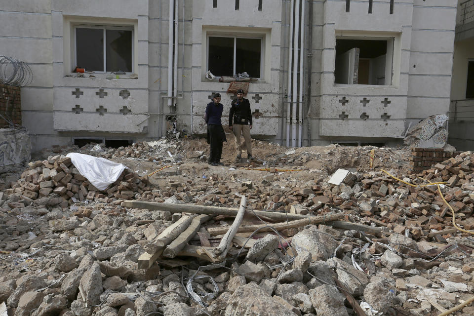 Police officers examine the site of Monday's suicide bombing in Peshawar, Pakistan, Feb. 2, 2023. A suicide bomber who killed 101 people at a mosque in northwest Pakistan this week had disguised himself in a police uniform and did not raise suspicion among guards, the provincial police chief said on Thursday. (AP Photo/Muhammad Sajjad)