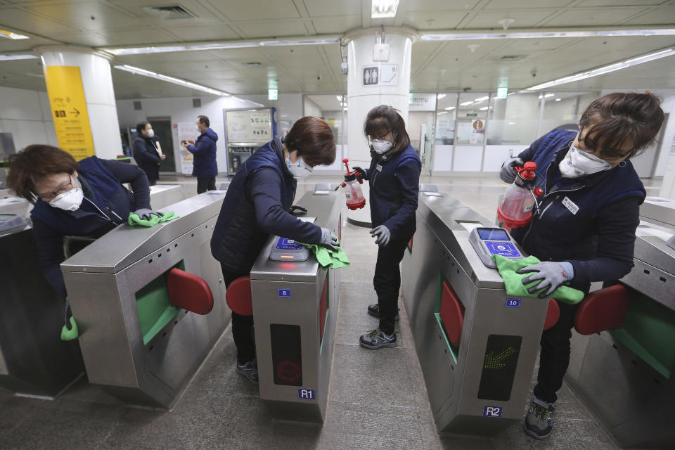 FILE - In this Jan. 28, 2020, file photo, employees disinfect ticket gates in hopes to prevent the contraction of the coronavirus at a subway station in Seoul, South Korea. Halting the spread of a new virus that has killed hundreds in China is difficult in part because important details about the illness and how it spreads are still unknown. (AP Photo/Ahn Young-joon, File)