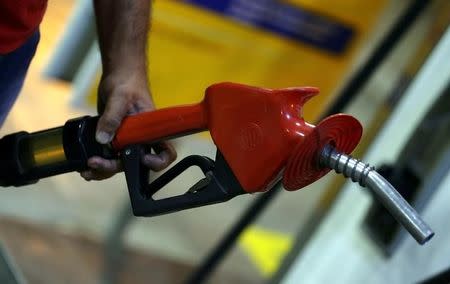 FILE PHOTO: An employee holds a gas pump at a petrol station in Sao Paulo, Brazil November 8, 2016. REUTERS/Paulo Whitaker/File photo