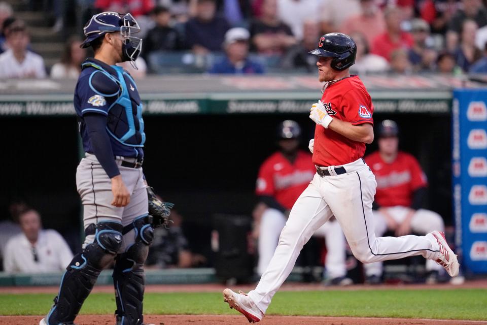 Cleveland Guardians' Myles Straw, right, runs past Tampa Bay Rays catcher Rene Pinto to score Sept. 1 in Cleveland.