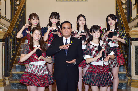 Thailand's Prime Minister Prayuth Chan-ocha gestures as he poses with Japan idol group AKB48 at Government House in Bangkok, Thailand, September 13, 2018. Thailand Government House/Handout via REUTERS