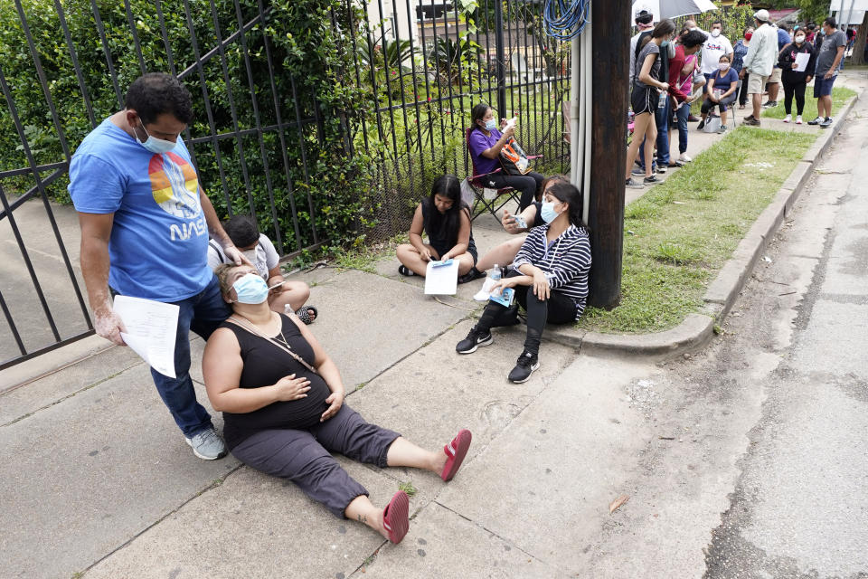 People wait in line at a free COVID-19 testing site provided by United Memorial Medical Center, Sunday, June 28, 2020, at the Mexican Consulate, in Houston. Confirmed cases of the coronavirus in Texas continue to surge. Texas Gov. Greg Abbott shut down bars again and scaled back restaurant dining on Friday as cases climbed to record levels after the state embarked on one of America's fastest reopenings. (AP Photo/David J. Phillip)