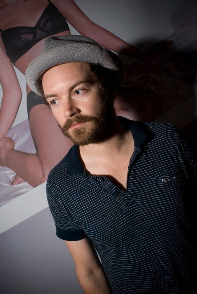 Danny Masterson casual, poster of model behind him.