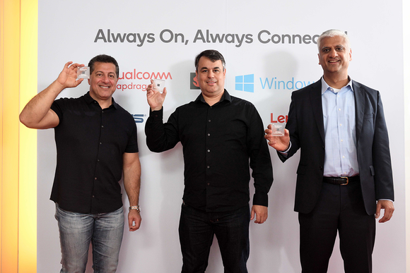 Three individuals holding Qualcomm chips.