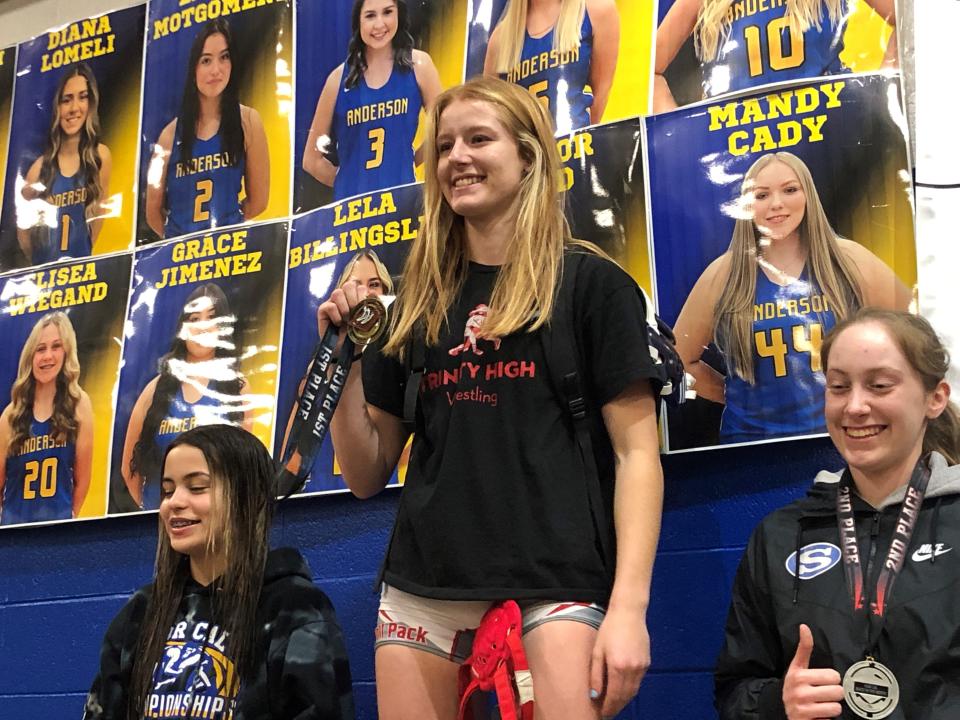 Trinity senior wrestler Sara Keating stands atop the podium at Anderson High School after winning the 128-pound title at Beast of the North tournament on Saturday, Jan. 7, 2023.