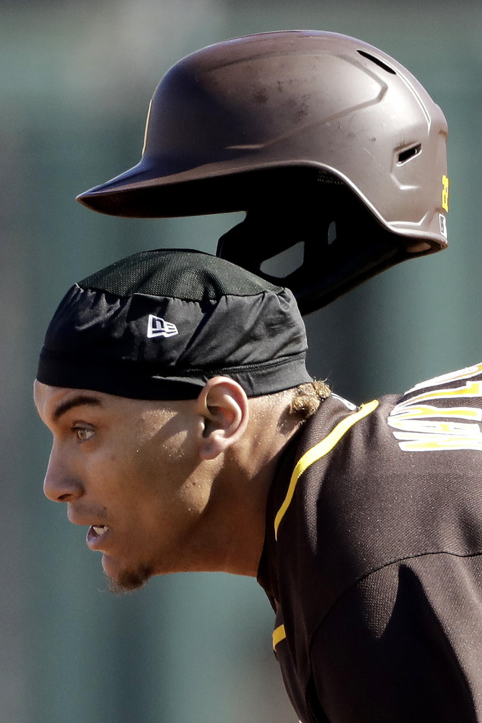 San Diego Padres' Josh Naylor looses his helmet as he advances safely to second base on a fly out by Manny Machado during the third inning of a spring training baseball game against the Kansas City Royals Monday, Feb. 24, 2020, in Surprise, Ariz. (AP Photo/Charlie Riedel)