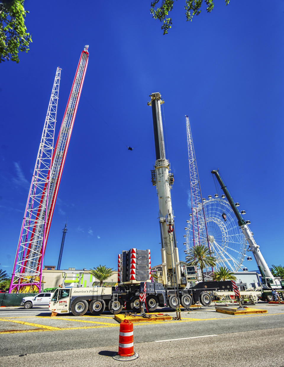 Work crews assemble the cranes that will be used to dismantle the Orlando FreeFall at ICON Park, on Tuesday, March 14, 2023 in Orlando, Fla. Almost a year after Tyre Sampson, a Missouri teen fell to his death, the 400-foot (122 meter) amusement ride was being dismantled this week in central Florida’s tourism corridor. (Ricardo Ramirez Buxeda/Orlando Sentinel via AP)