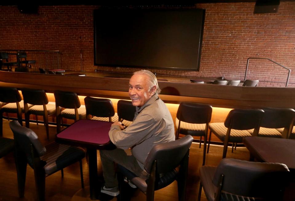 Man sits in the main showroom of a comedy club