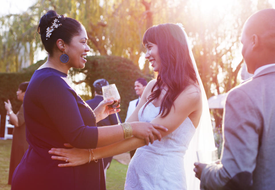 A woman talking to the bride at a wedding