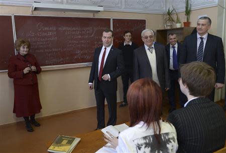 Russia's Prime Minister Dmitry Medvedev (2nd L) visits an upper secondary school, as Crimea's Prime Minister Sergei Aksyonov (R) stands nearby, in the Crimean city of Simferopol, March 31, 2014. REUTERS/RIA Novosti/Alexander Astafyev/Pool